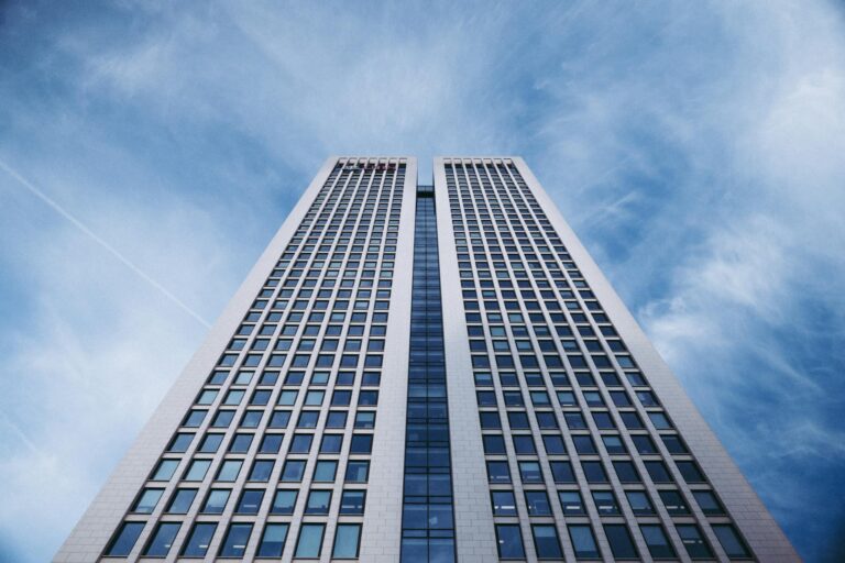 Hochhaus aus der Froschperspektive vor blauem Himmel